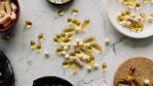 A top view of assorted capsules and pills displayed on a marble surface, showcasing a variety of medicines.
